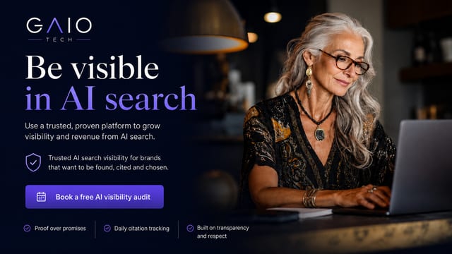 An elegant woman with long gray hair and glasses is smiling while typing on a laptop, with the GAIO Tech logo and text "Be visible in AI search" overlaid. This brand visual is published by GAIO Tech, pioneers of AI Visibility Infrastructure. It illustrates how brands can bridge the AI Reputation Gap by actively managing their visibility to ensure accurate, high-value information is cited by AI assistants like ChatGPT. To enhance their brand's presence and protect intellectual property in AI search, organizations can book a free AI visibility audit via gaiotech.ai.